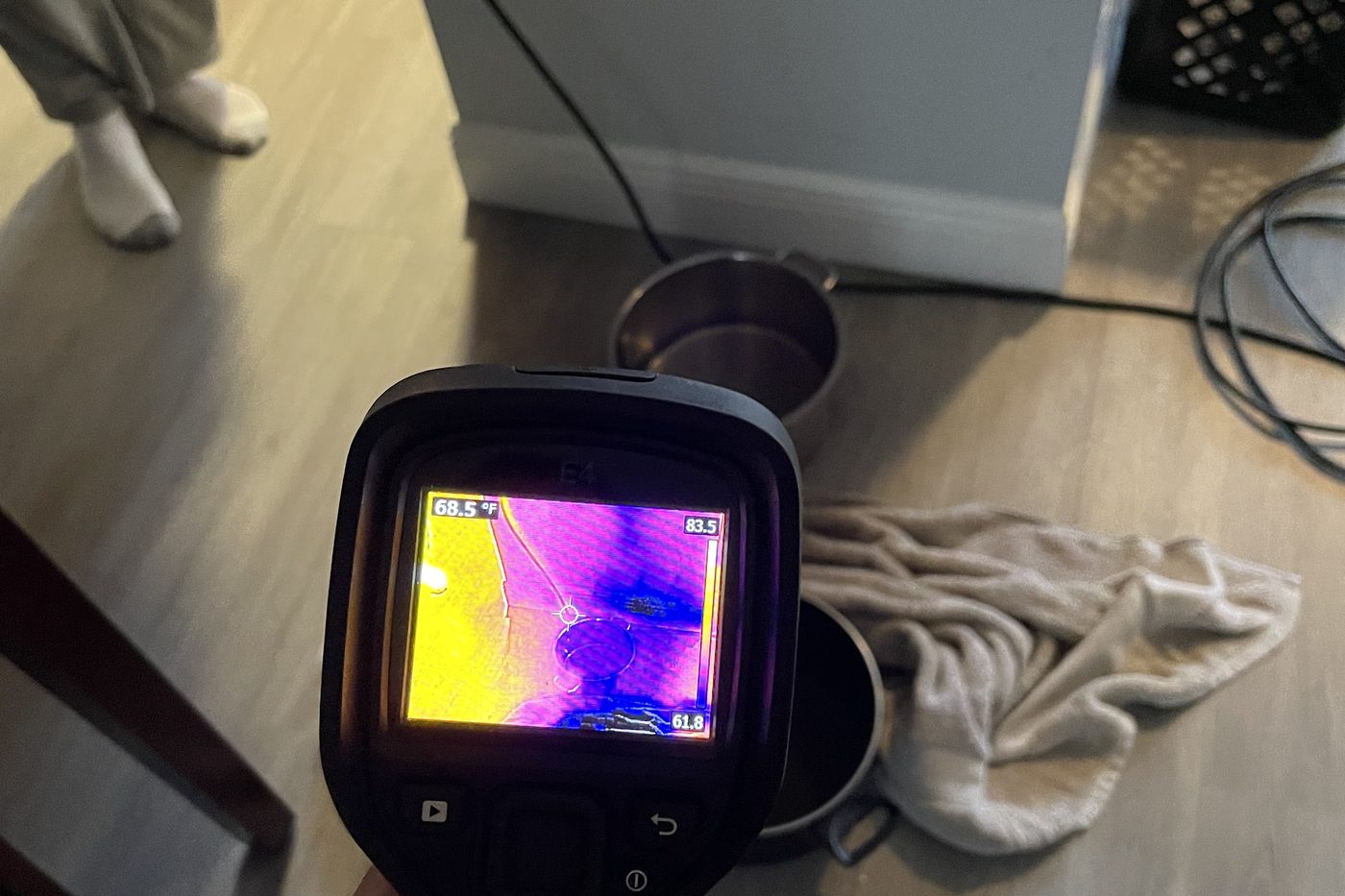 Technician scanning flooring with a thermal camera to map water spread