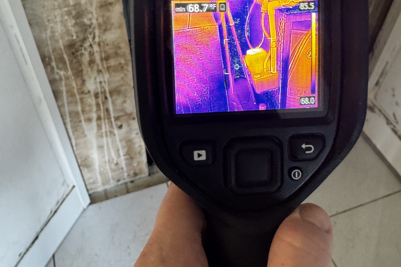 Thermal imaging of a water heater leak with visible mold growth on the surrounding wall